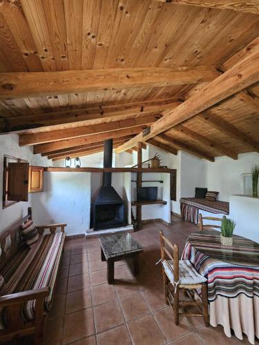 a living room with a fireplace and wooden ceilings at Cortijo del Cura By Travel Home in Cortijos Nuevos