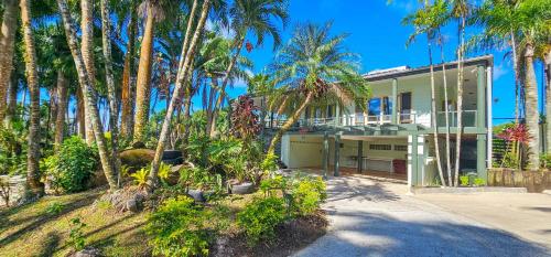 an exterior view of a house with palm trees at Tipani Lodge - Free and Unlimited Wifi in Rarotonga