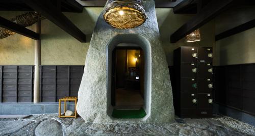 a bathroom with a rock wall with a mirror at Sennenmatsu in Imabari