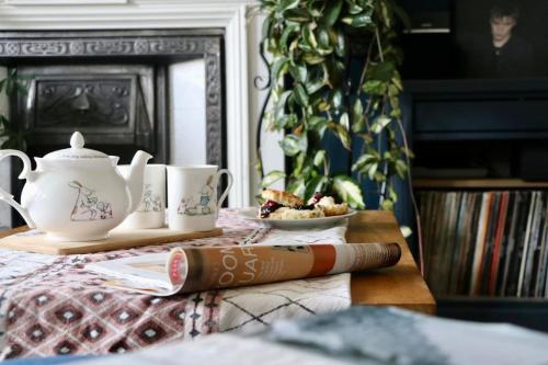 a table with a tea pot and cups on it at Hyem at Cullercoats in Cullercoats