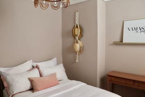 a bedroom with a bed with white sheets and a chandelier at Hyem at Cullercoats in Cullercoats