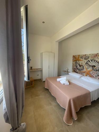 a bedroom with a bed and a large window at Casa Vacanza Marijò in Sant'Isidoro