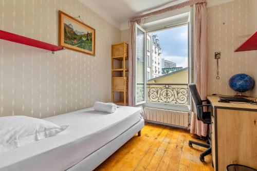 une chambre avec un lit, un bureau et une fenêtre dans l'établissement Chanzy-Spacieux appartement familial Place de la Nation, à Paris