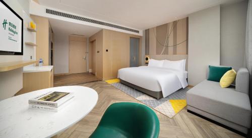 a hotel room with a bed and a table at Holiday Inn Dujiangyan Ancient Town by IHG in Dujiangyan