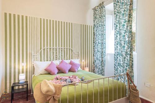 a bedroom with a green bed with pink pillows at Happy Childhood by the Stream in Tre Colli