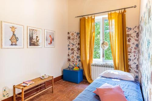a bedroom with a bed and a window with yellow curtains at Happy Childhood by the Stream in Tre Colli