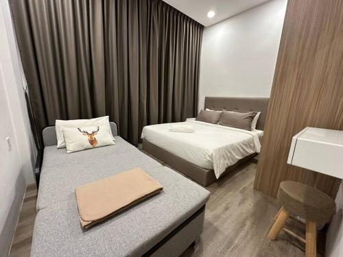 a small hotel room with two beds and a desk at Jk Yarra Park Resort Style 8Pax 3BedR2BathR in Kuching