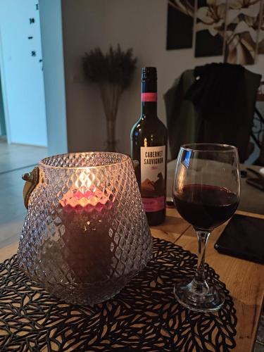 a glass of wine next to a bottle of wine at Gornji Milanovac Apartment in Gornji Milanovac