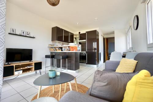 un salon avec un canapé et une table dans l'établissement Cabestan piscine 100m de la plage, à Guidel