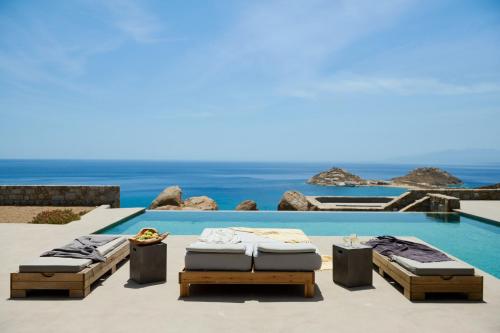two beds on a patio next to a swimming pool at Villa Aqua Marine in Kalafatis