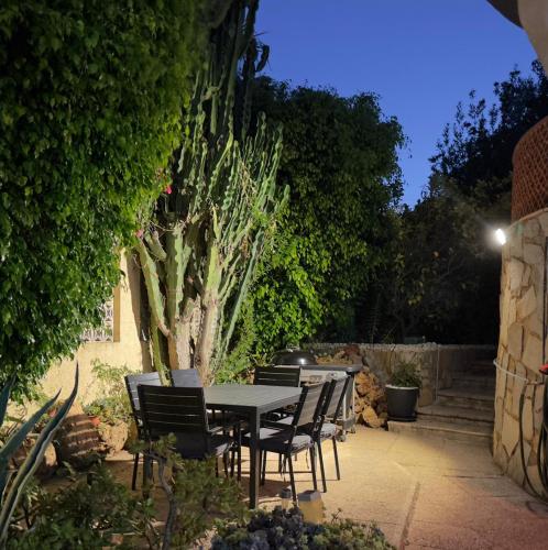 a table and chairs in a garden at night at Chalet Los Almendros con piscina privada in Calpe