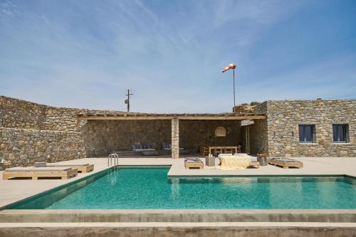 a swimming pool in front of a stone building at Villa Aqua Marine in Kalafatis
