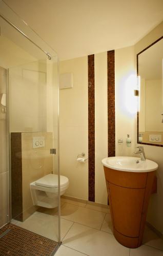 a bathroom with a toilet and a sink at Hotel Am Helmwartsturm in Andernach
