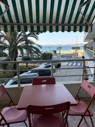 d'une table et de chaises sur un balcon avec vue sur la plage. dans l'établissement Vue mer à deux pas de la plage, à Sainte-Maxime