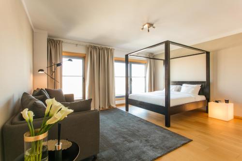 ein Wohnzimmer mit einem Bett und einem großen Spiegel in der Unterkunft Your Lisbon Home Parque das Nações in Lissabon