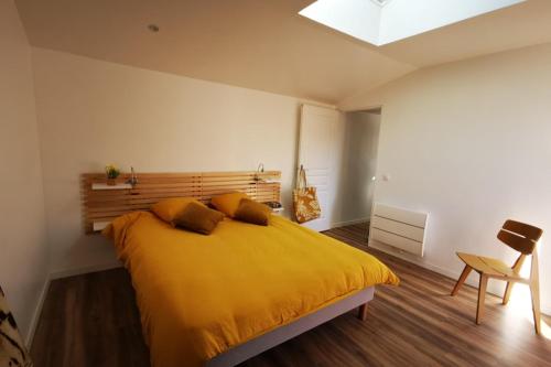 a bedroom with a large yellow bed with a skylight at Appartement dans maison d'architecte avec terrasse in Saint-Lunaire