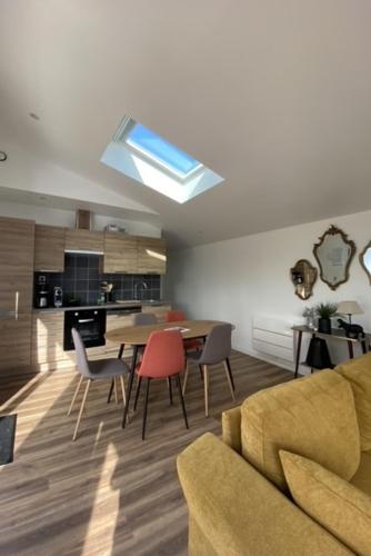 un salon avec une table et des chaises et une cuisine dans l'établissement Appartement dans maison d'architecte avec terrasse, à Saint-Lunaire