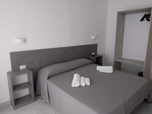 a bedroom with a bed with two white slippers on it at Villa3 Cancelli Guesthouse B&B via del Mare Formia in Formia