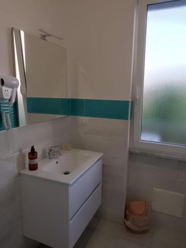 a white bathroom with a sink and a window at Villa3 Cancelli Guesthouse B&B via del Mare Formia in Formia
