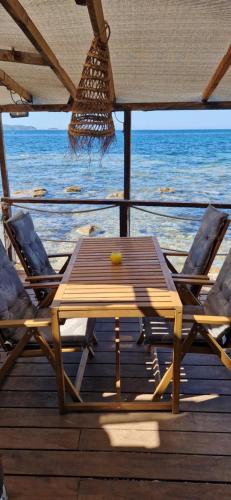 a wooden table and chairs on a deck near the ocean at Stella Maris in Hyères