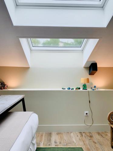 a bedroom with a skylight in the ceiling at Le Florida Auberge contemporaine in Castéra-Verduzan