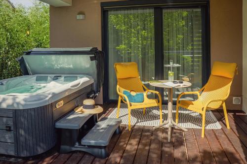a room with a bed and two chairs and a table at Imola Hotel Platán in Eger