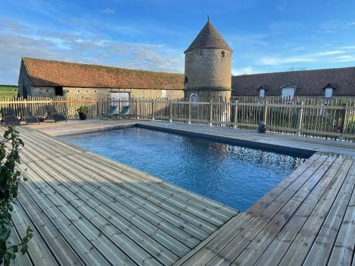 une piscine avec une terrasse en bois et une clôture dans l'établissement Domaine du SAAJ Côte Opale 8 personnes, à Hesdin-lʼAbbé
