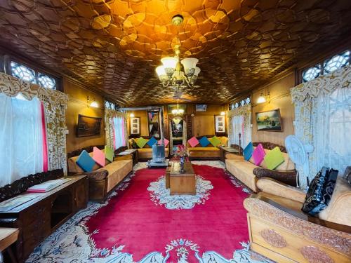 a living room with couches and a red rug at New Sea Palace Houseboats in Srinagar