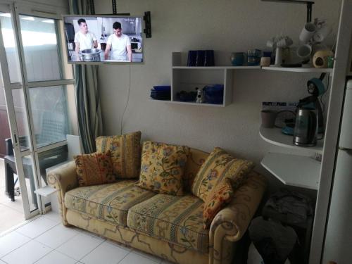 un salon avec un canapé et une télévision dans l'établissement duplex atypique avec magnifique vue mer et baie d'Agay, à Saint-Raphaël