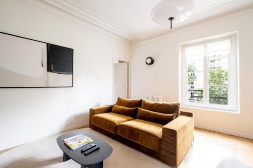 un salon avec un canapé et une télévision dans l'établissement Appartement Latté - Welkeys, à Paris