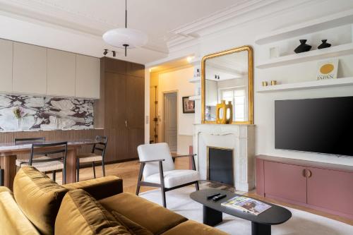 un salon avec un canapé et une télévision dans l'établissement Appartement Latté - Welkeys, à Paris