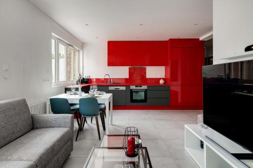un salon avec des armoires rouges et une table avec des chaises dans l'établissement Appartement Brivi - Welkeys, à Lille
