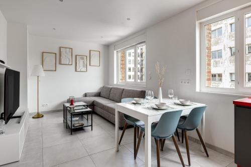 un salon avec un canapé, une table et des chaises dans l'établissement Appartement Brivi - Welkeys, à Lille