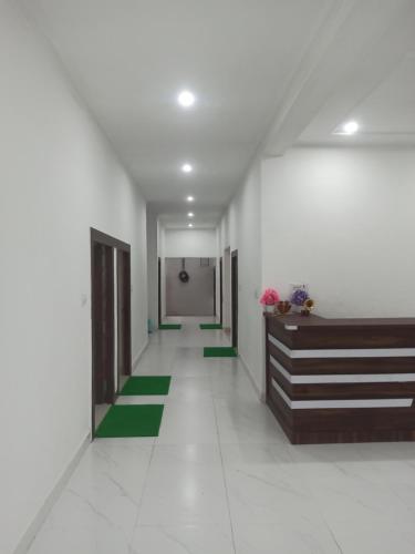 a hallway with green and white floors and doors at Abhiram Homestay in Khajurāho