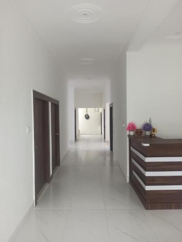 a hallway with white walls and a long corridor at Abhiram Homestay in Khajurāho