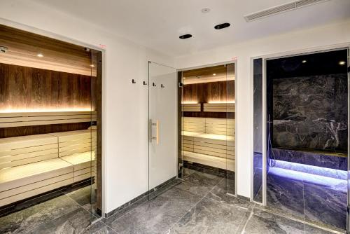 a walk in closet with wooden cabinets and a glass door at Das Förstereck in Viehhofen