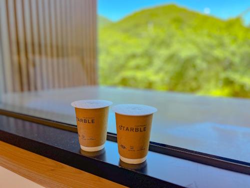two coffee cups sitting on top of a table at Hotel Ganwoljae in Ulsan