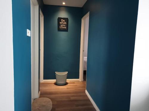 a hallway with a blue wall and a trash can at JK UpperSanctuary 8Pax 3BedR 2BathR 1Carpark in Kuching