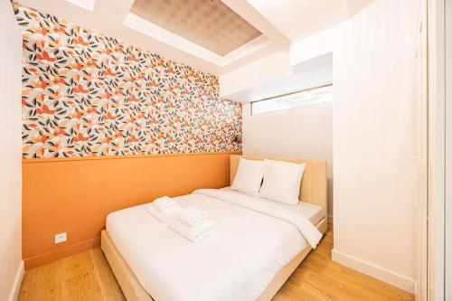 - un petit lit dans une chambre ornée d'une peinture murale dans l'établissement Appart 8pers # 3 Bedrooms # Pereire # Paris 17, à Paris