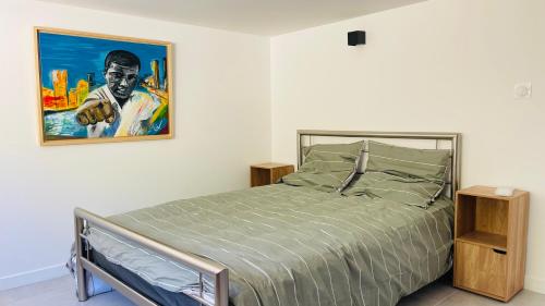 a bedroom with a bed and a painting on the wall at 3 pièces avec piscine privative in Collioure