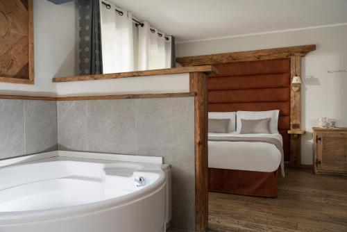 a bathroom with a bath tub and a bed at Locanda Bellevue in Pré-Saint-Didier