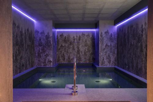 a bathroom with a tub with purple lighting at Locanda Bellevue in Pré-Saint-Didier