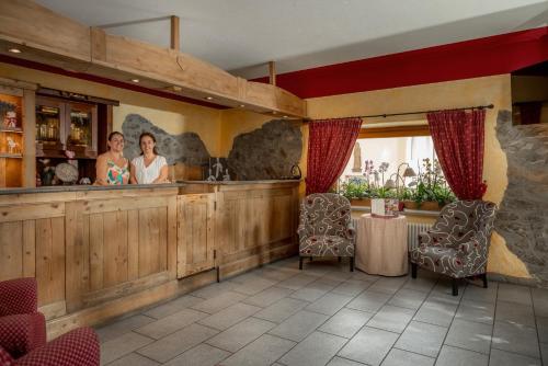two women standing at a bar in a restaurant at Locanda Bellevue in Pré-Saint-Didier