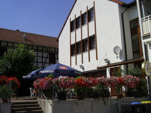 a building with flowers and an umbrella in front of it at An der Linde in Eisenach