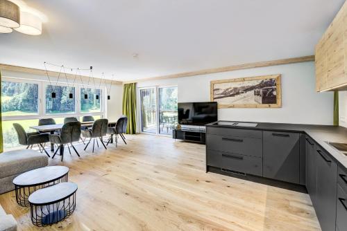 a kitchen and living room with a table and chairs at Das Förstereck in Viehhofen