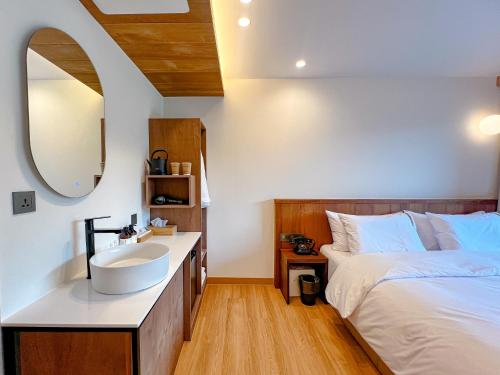 a bedroom with a white sink and a bed at Hotel Ganwoljae in Ulsan