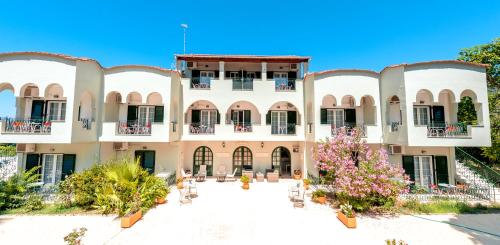 anterior view of a building with a courtyard at Vassilis Paradise Garden Aparthotel in Agios Georgios Pagon