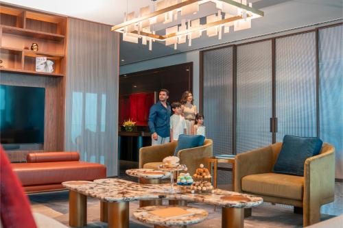 a family is standing in a living room at Conrad Bahrain Financial Harbour in Manama