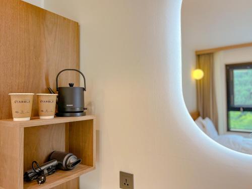 a room with a room with a bed and a mirror at Hotel Ganwoljae in Ulsan