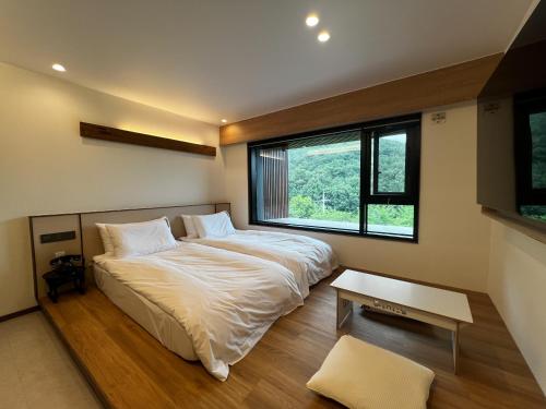 a bedroom with a large bed and a window at Hotel Ganwoljae in Ulsan